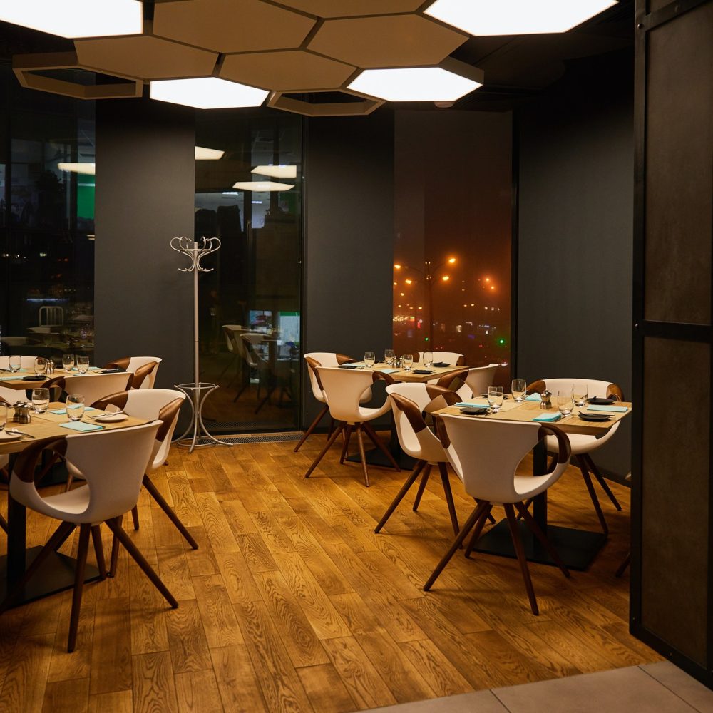 glasses near plates on wooden tables in modern restaurant